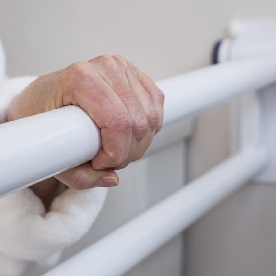 a hand reaching for balance, holding onto the PT Rail