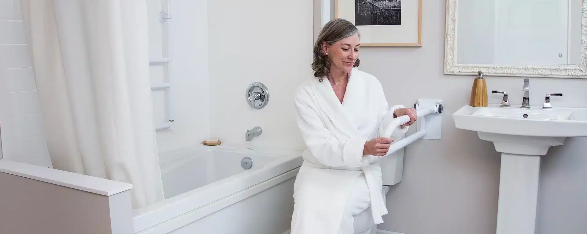 A senior woman using a white Healthcraft PT Rail to help her stand from the toilet.