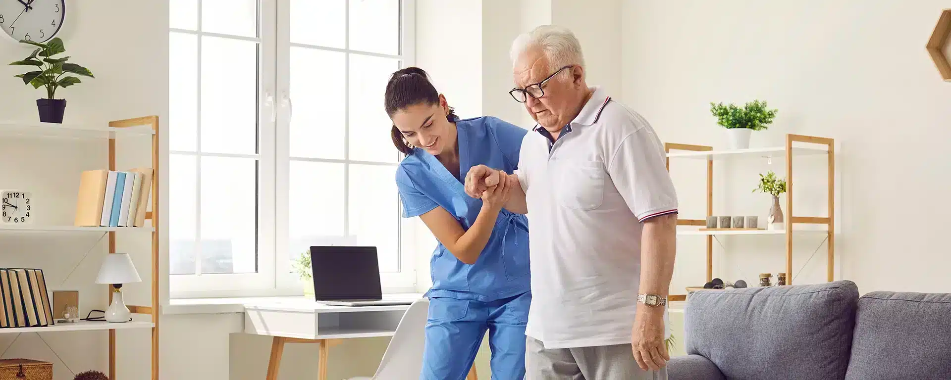 Young occupational therapist helping senior man walk.